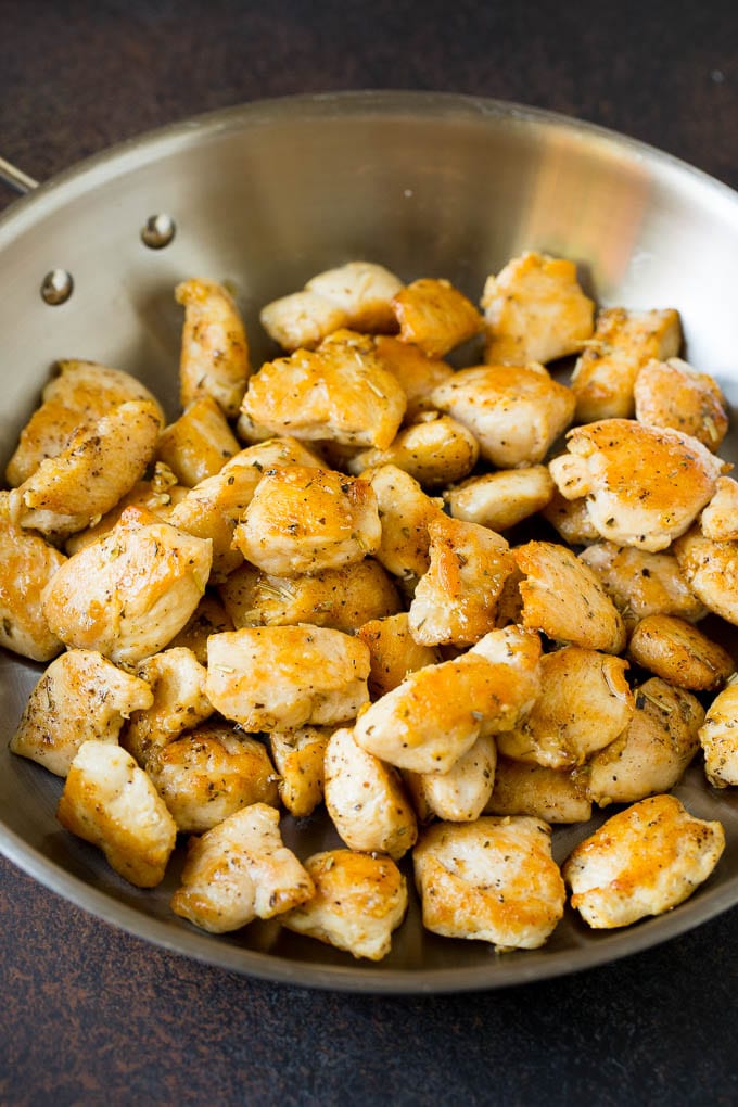Diced sauteed chicken in a skillet.