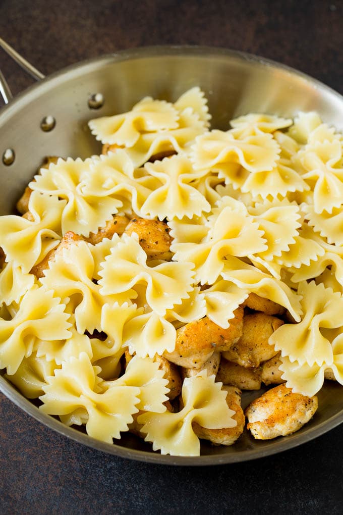 Chicken and farfalle pasta in a pan.