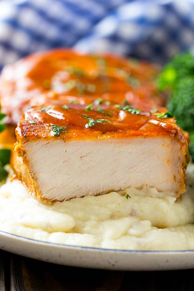 A cross section of a honey garlic pork chop served on mashed potatoes.