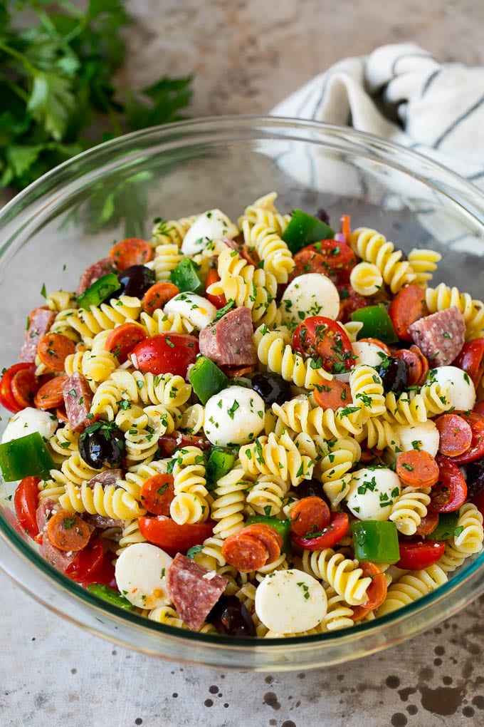 A bowl of Italian pasta salad filled with meats, cheese and vegetables.