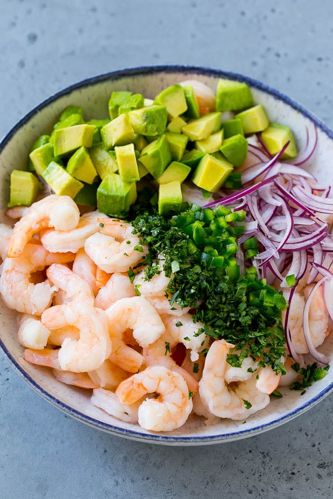 Shrimp, red onion, avocado, jalapeno and cilantro in a serving bowl.