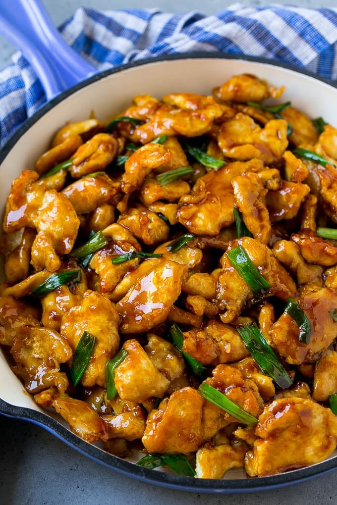 Mongolian chicken with green onions in a skillet.