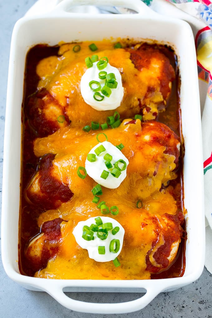 A dish of baked salsa chicken topped with cheese and sour cream.