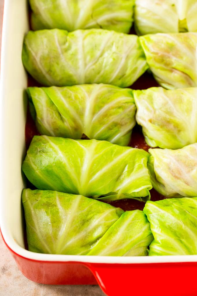 Cabbage leaves wrapped around beef and rice in a baking dish.